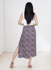 Back View of Model wearing midi skirt with side slit and patterned fabric