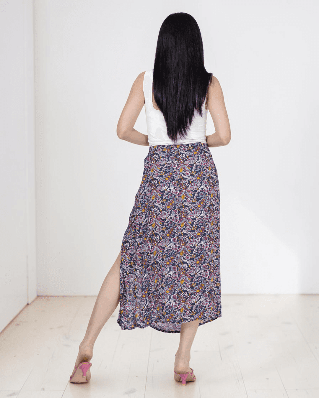 Back View of Model wearing midi skirt with side slit and patterned fabric