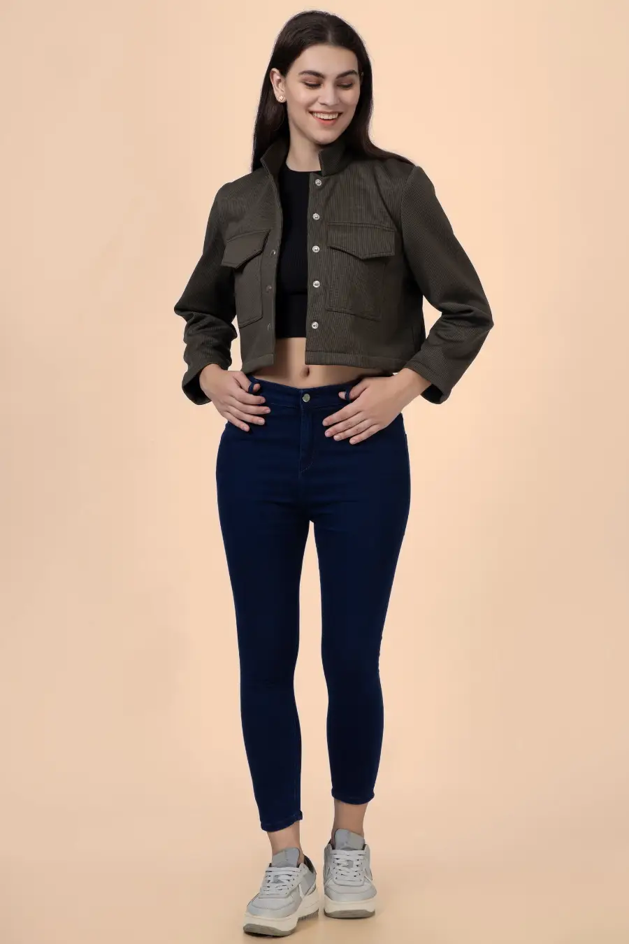 Full-body view of the model wearing the 'Noelle' short jacket, styled with jeans and sneakers for a casual yet structured outfit.