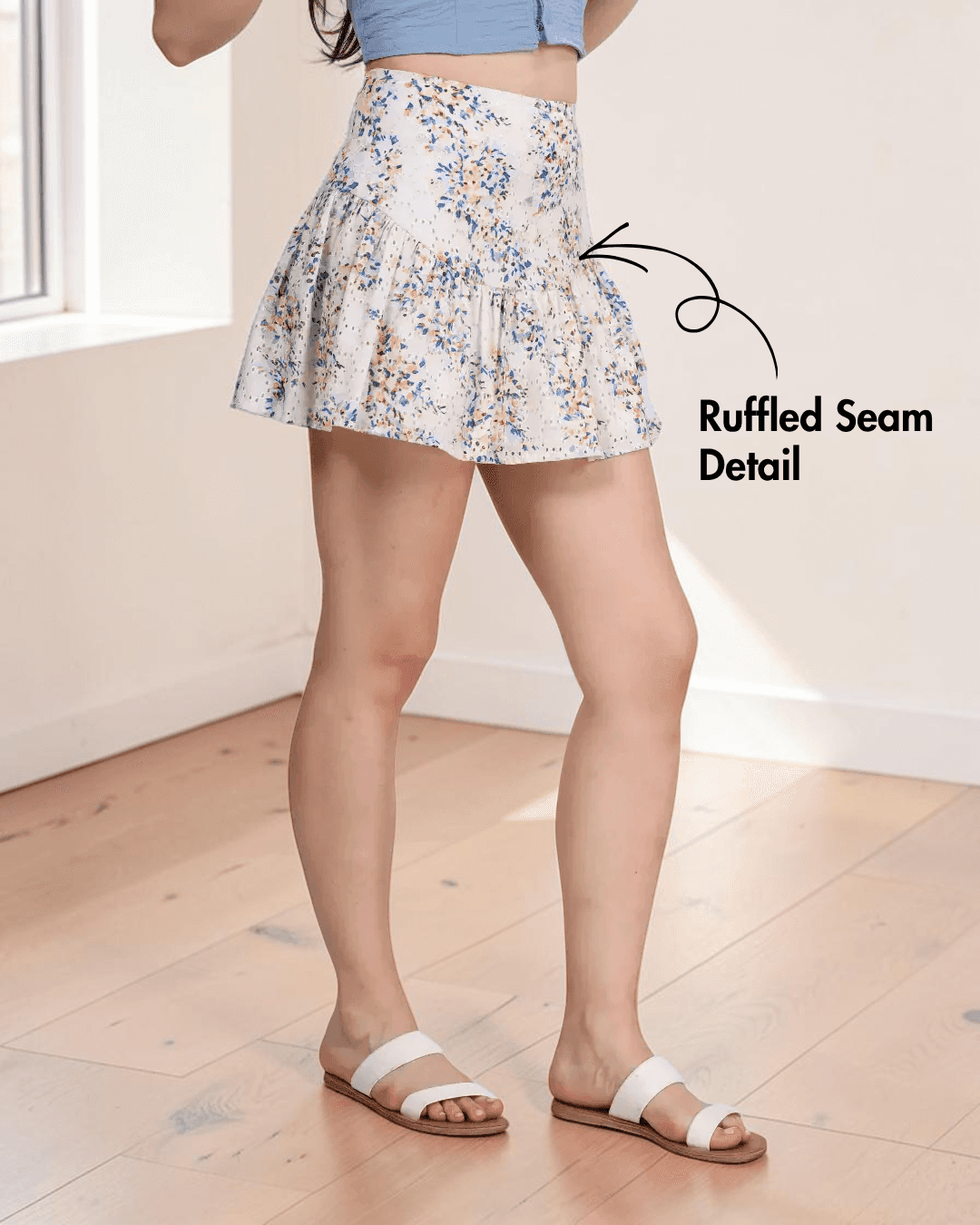 Side view of floral mini skirt with ruffled seam detail and fitted waist