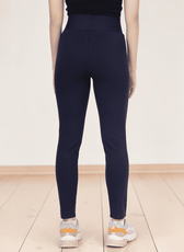 Back view of woman in navy leggings sewing pattern highlighting high waist and fitted style