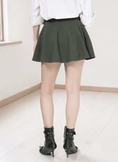 Close-up of model in green skater skirt showing pattern details and design