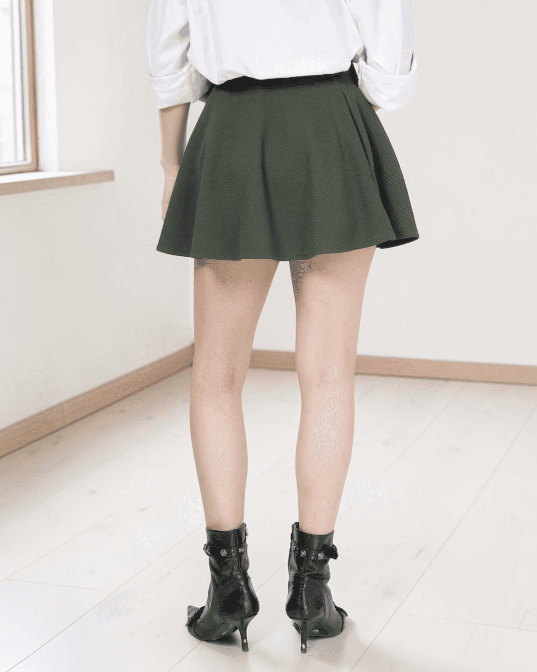 Close-up of model in green skater skirt showing pattern details and design