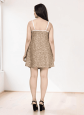 Back view of gold sequin mini dress with spaghetti straps and white trim