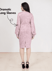 Back view of woman in pink sequin dress with dramatic long sleeves and slit
