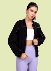 Model wearing the Naomi windbreaker, a lightweight jacket with a relaxed fit, elasticated hem, and subtle piping details. Perfect for breezy weather and seasonal transitions.