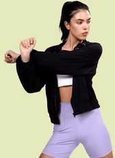 Stretching in the Naomi windbreaker, showcasing its comfortable fit and elastic cuffs. A stylish and functional outerwear piece for active and casual wear.