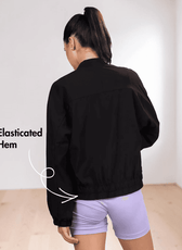 Back View of Model wearing women's windbreaker jacket Naomi with pattern details and purple shorts