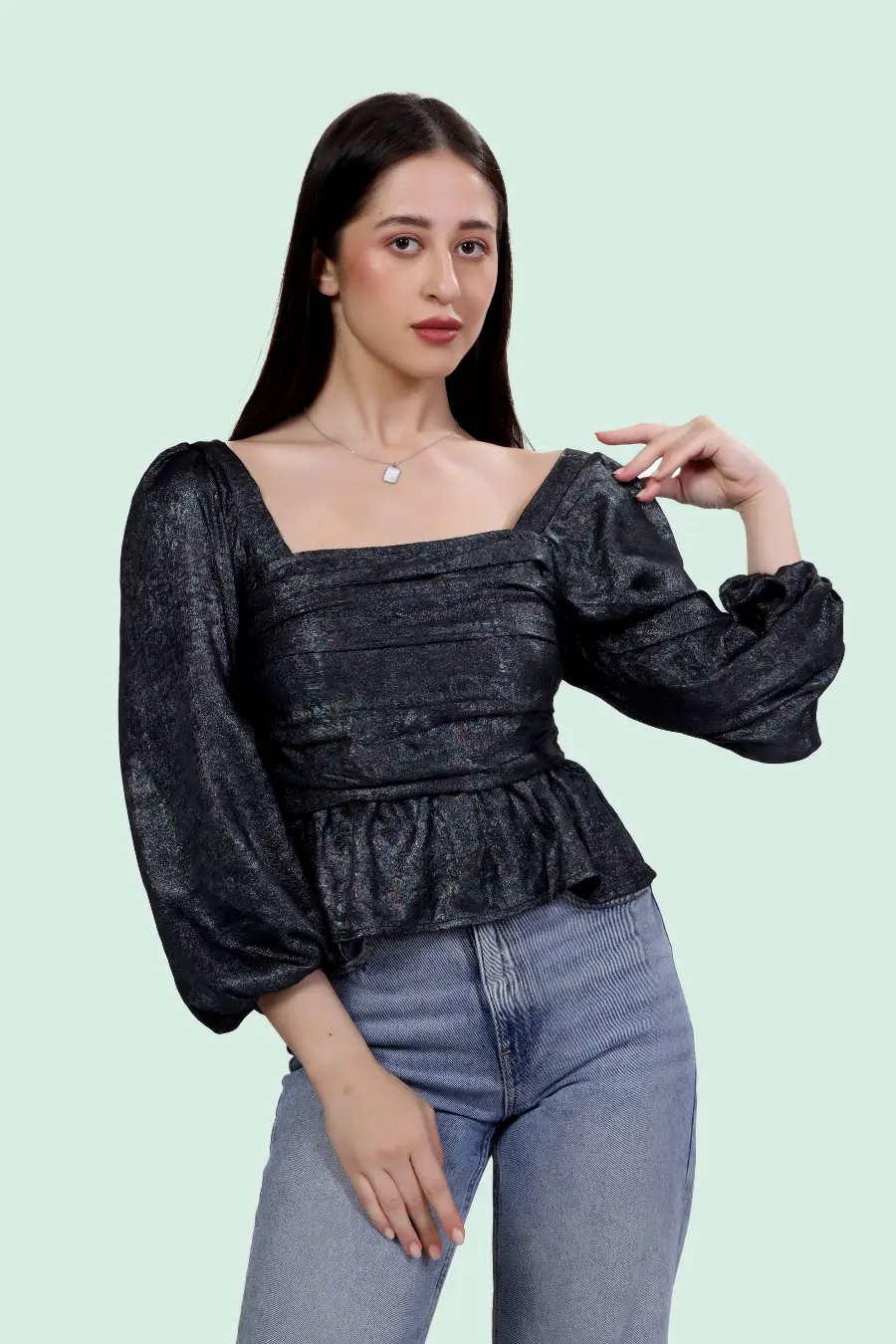 Reese Peplum Top Sewing Pattern modeled in black fabric, featuring square neck, long puff sleeves, and ruched front for a dramatic silhouette.