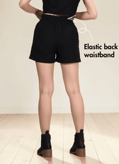 Back view of black shorts sewing pattern with elastic waistband and buttons
