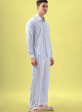 Side view of a model in a blue and white striped men's pajama set from the 'Arbor' sewing pattern. Comfortable fit with a classic button-up design.