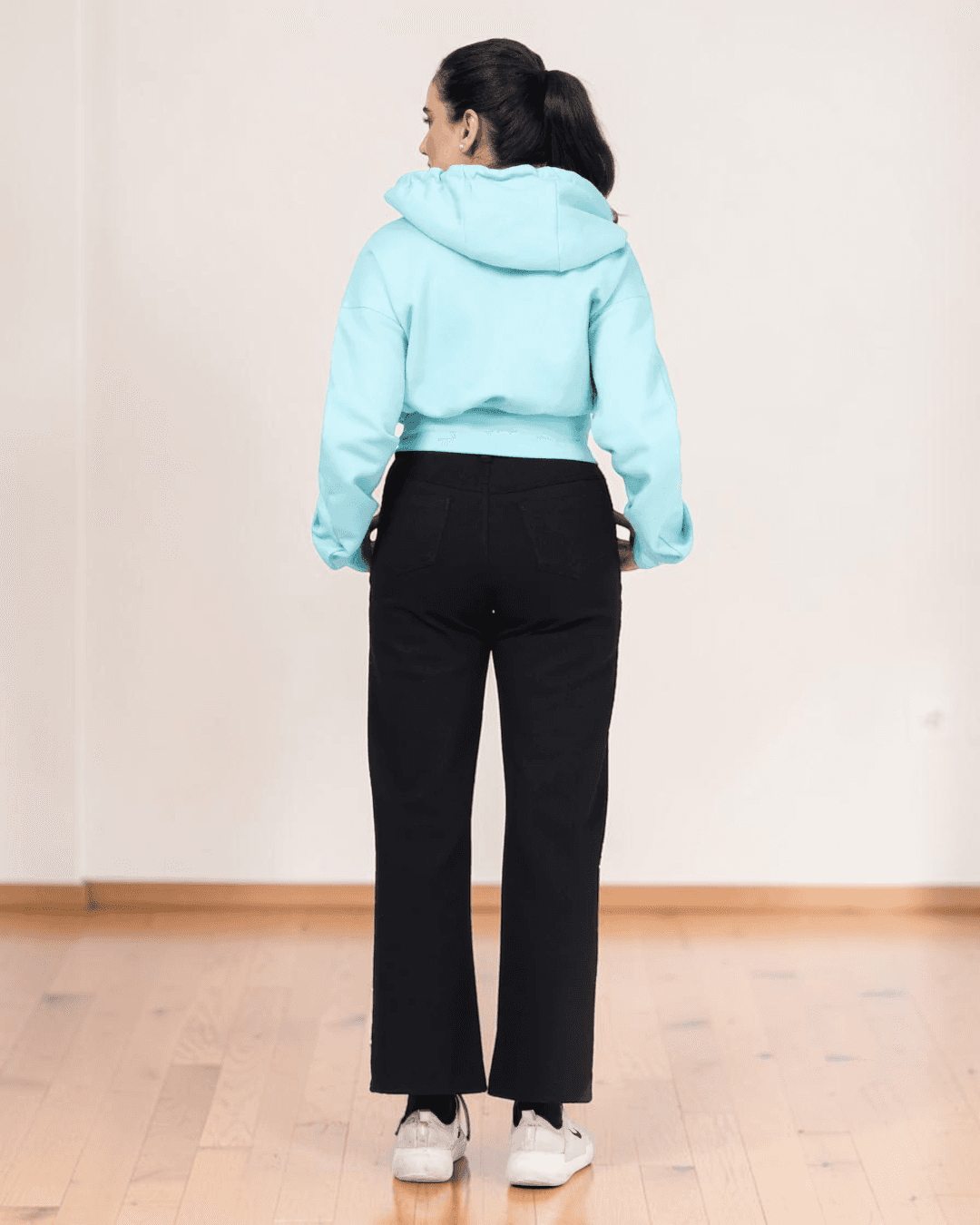 Back view of light blue cropped hoodie with hood and long sleeves