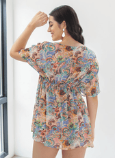 Back view of Model in colorful kaftan with soft draping short sleeves and wide boat neckline