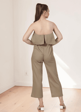 Back view of beige strapless jumpsuit with overlay and zipper closure