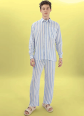 Another model showcasing the 'Arbor' men's pajama set sewing pattern. Striped cotton fabric with a button-up shirt and elastic-waist pants.