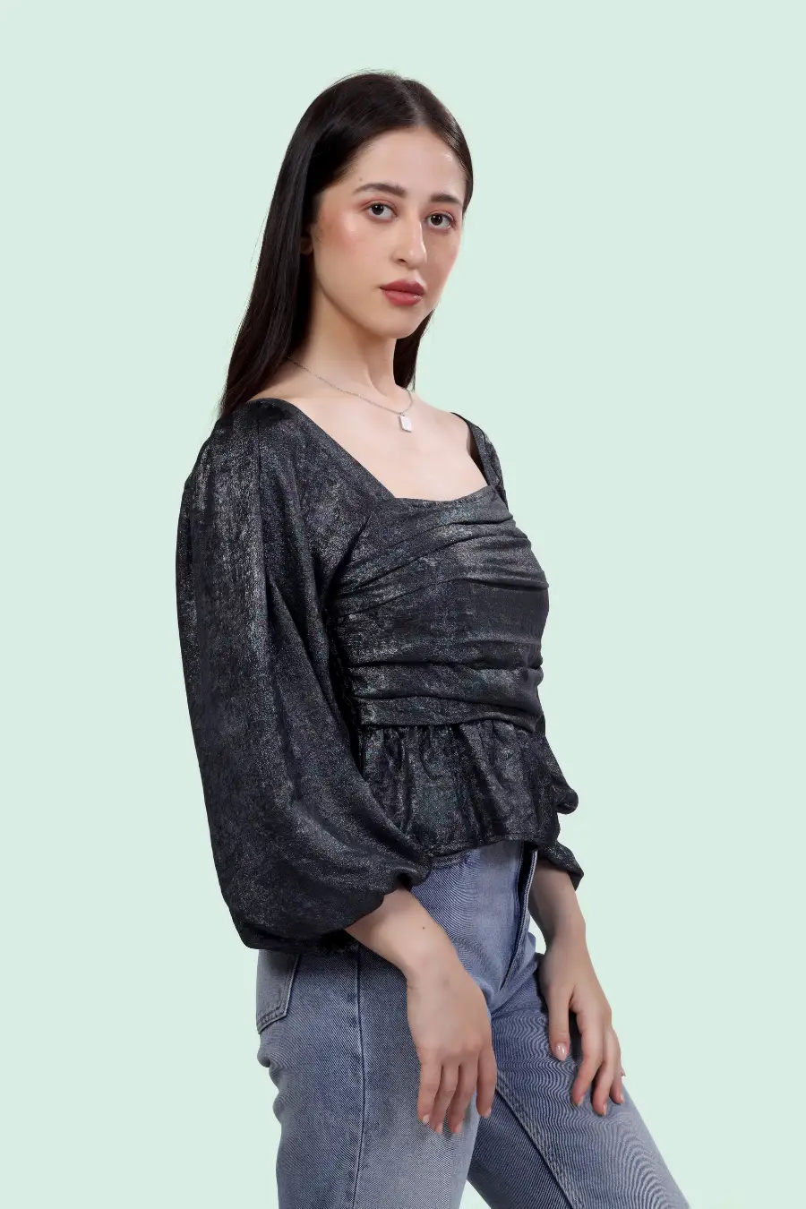 Side view of Reese Peplum Top Sewing Pattern in black fabric, highlighting ruched bodice, square neckline, and puff sleeve construction.