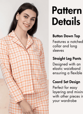 Close-up of peach plaid pajama pattern with button-down top and long sleeves
