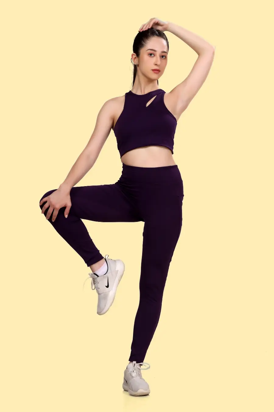 Model demonstrating the flexibility of the 'Layla' activewear coord set, featuring a cutout sports bra and high-waisted leggings for maximum movement.