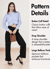 Women wearing blue cropped shirt with large bellows pockets, button cuffs, drop shoulder, and long sleeves