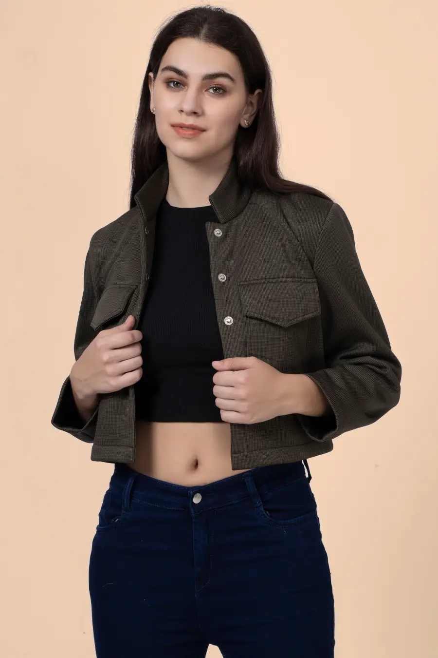 Model adjusting the 'Noelle' short jacket, showcasing its stylish cropped fit, button closure, and structured design.