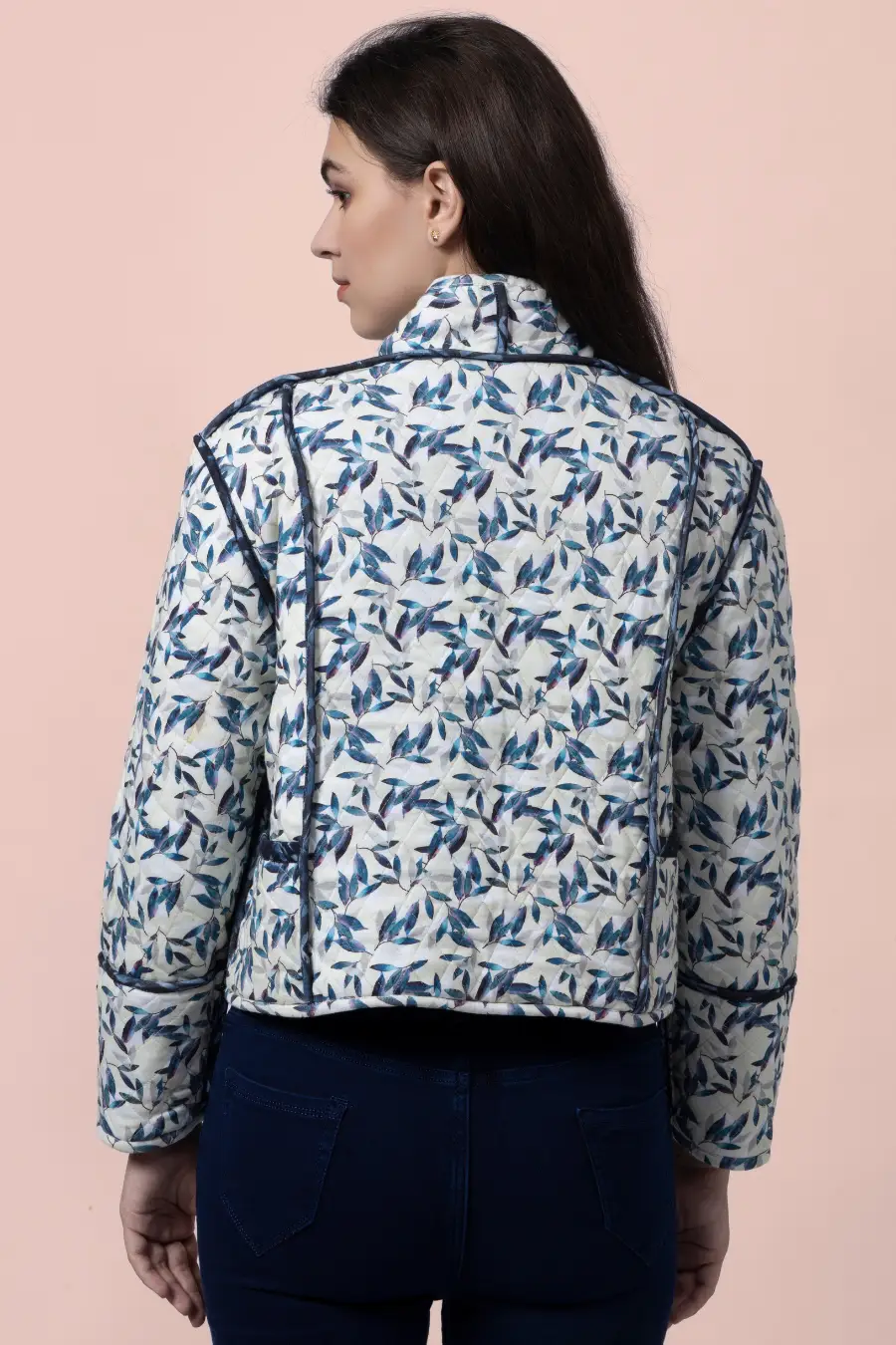 Back view of the Romy reversible quilted jacket in a blue and white leaf pattern. Features structured contrast binding for a stylish finish.