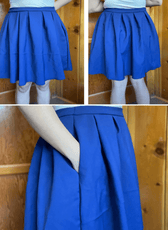 Blue structured box pleats skirt worn by a model outdoors, showcasing pleated design