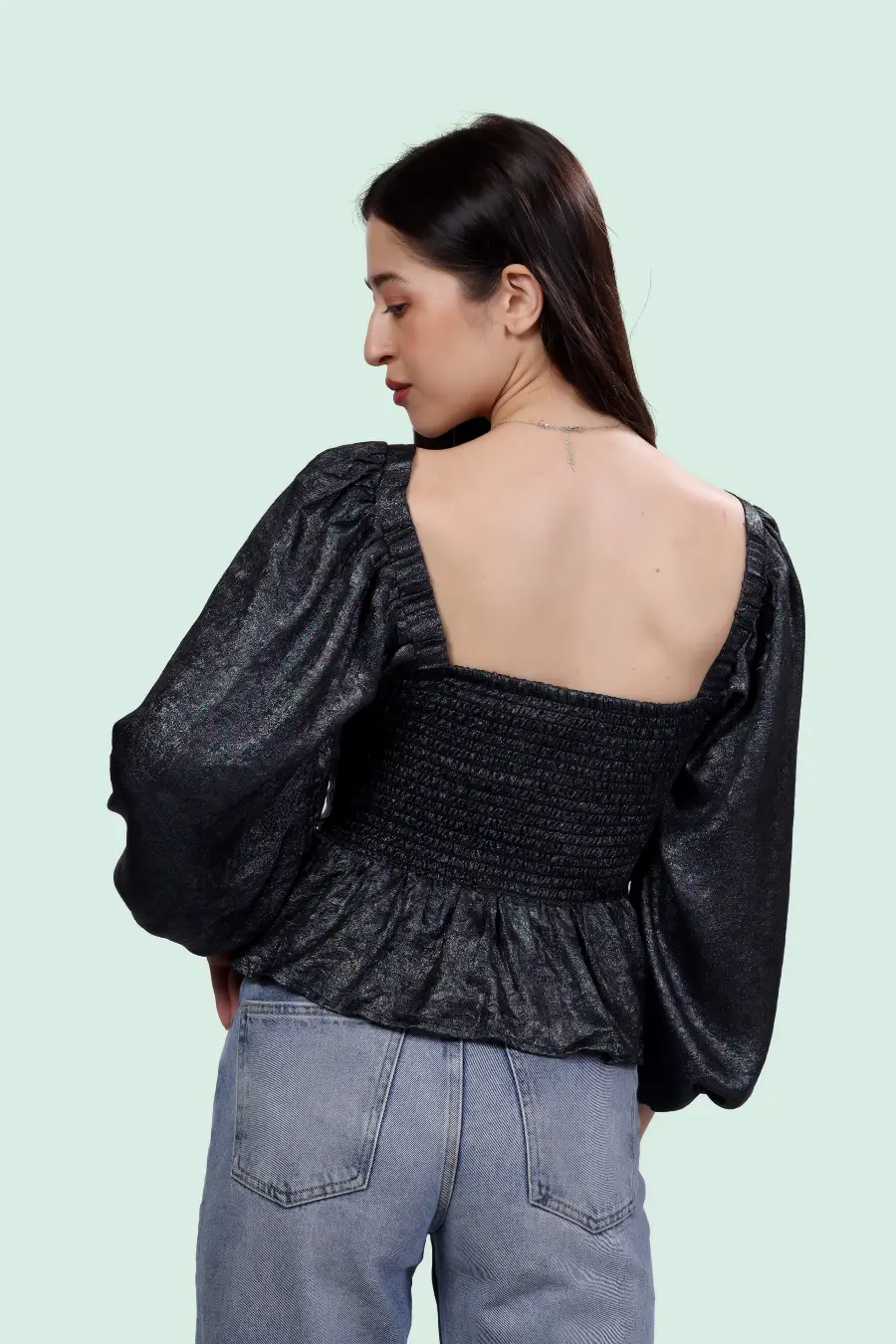 Back view of Reese Peplum Top Sewing Pattern showing smocked panel and square neckline, paired with casual denim jeans.