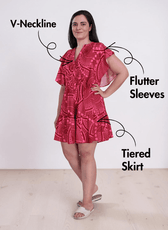 Woman in pink patterned Flutter Sleeve Dress with V-Neck and Tiered Skirt