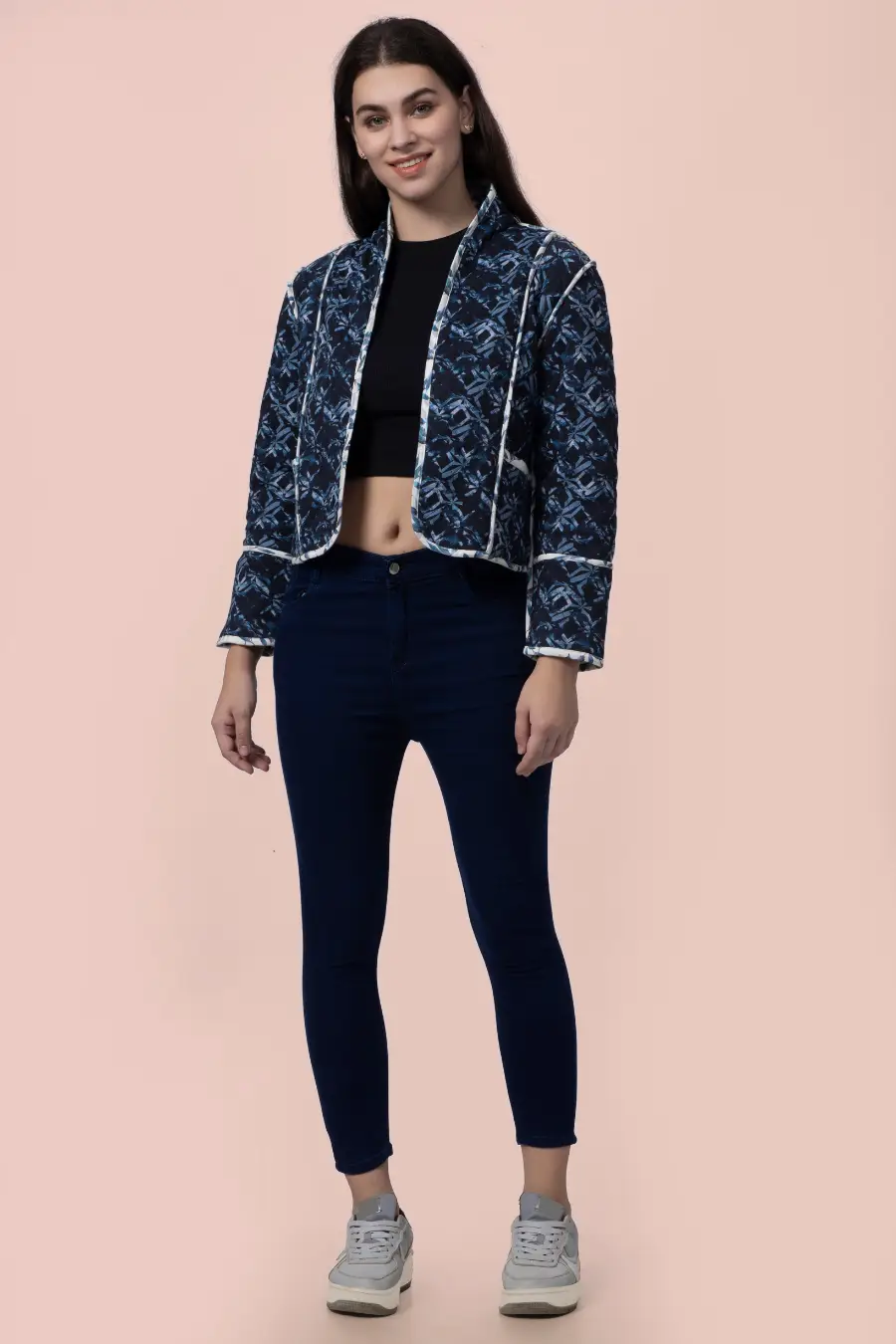 Front view of the Romy reversible quilted jacket in a dark blue geometric pattern. A hip-length, structured outerwear piece with contrast binding.