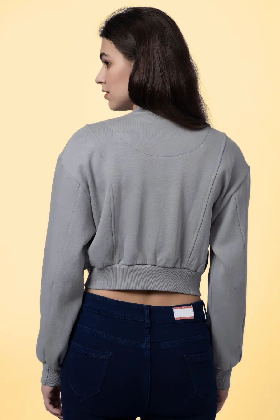 Back view of the 'Raya' bomber jacket sewing pattern, showcasing the structured paneling and ribbed waistband for a snug fit.