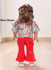 Back view of doll with floral top, red pants, and pink sandals, showing velcro closure