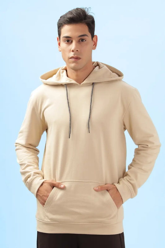 Beige men's hoodie made using the 'Atlas' sewing pattern. Features a relaxed fit, kangaroo pocket, ribbed cuffs, and an adjustable drawstring hood.