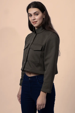 Side view of the 'Noelle' cropped jacket, highlighting its structured silhouette, button closure, and utility-style chest pockets.