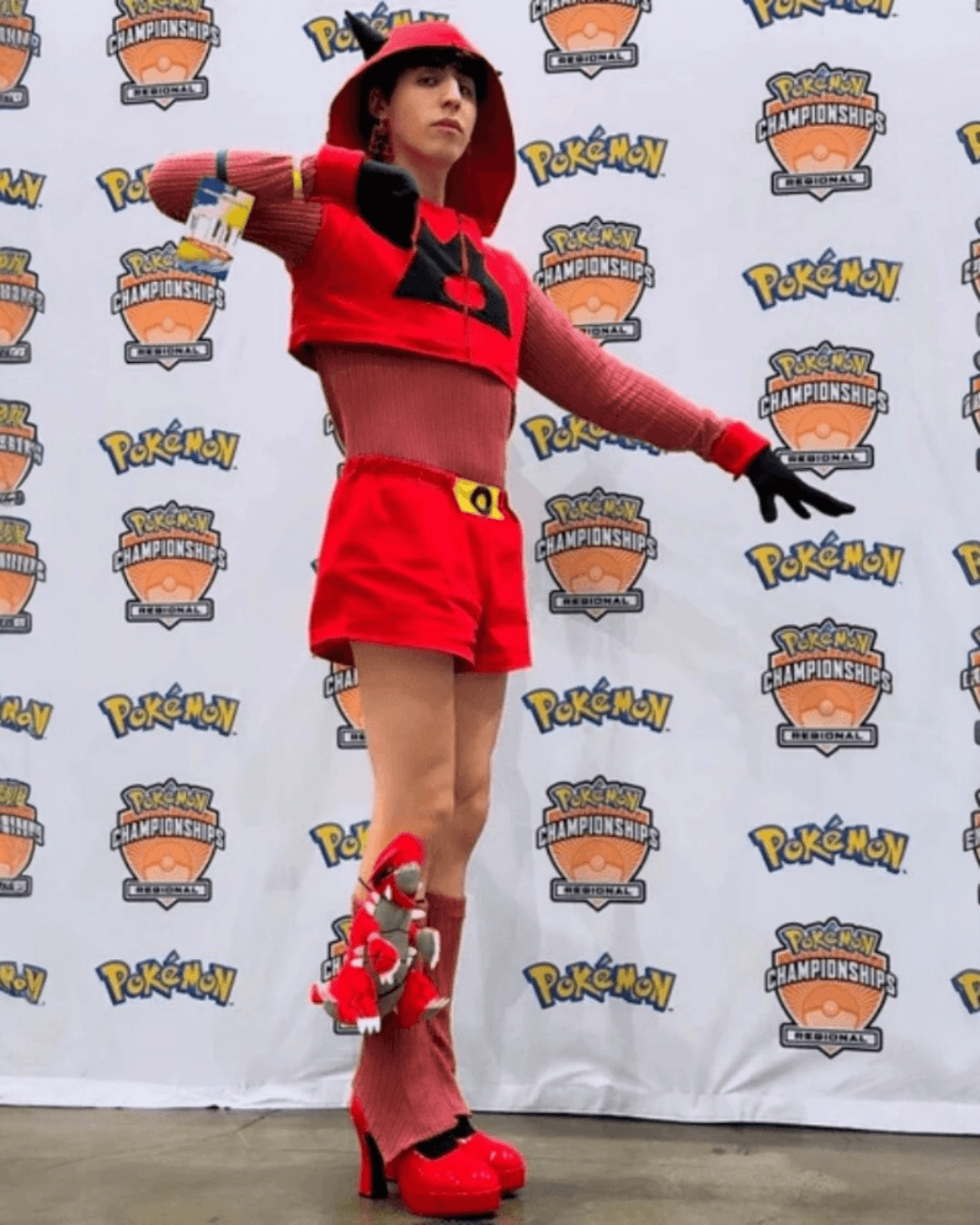 Person dressed in a red and black Pokémon-themed costume at a Pokémon Championships event