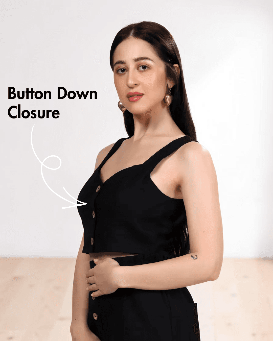 Model wearing black crop top sewing pattern with wide straps and button closure, side view