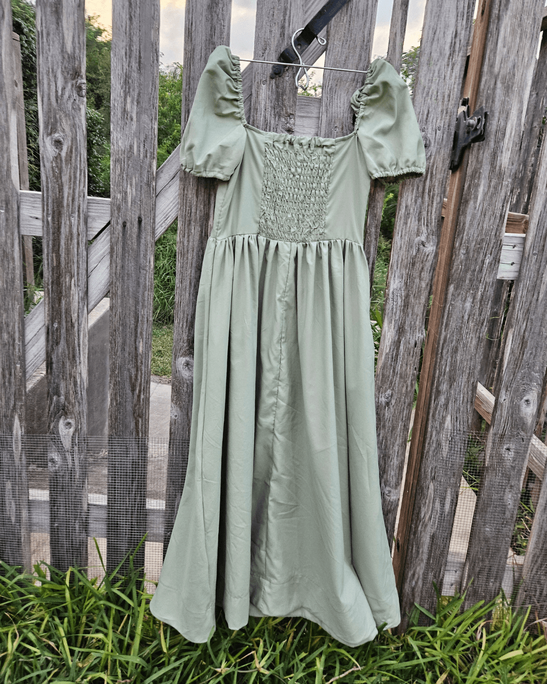 Back view of burgundy dress with elasticated smocked back panel and puff sleeves