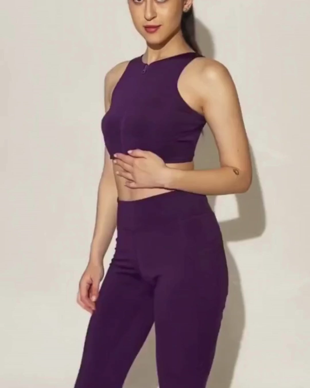 Model wearing purple activewear crop top and leggings