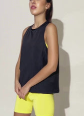 Model showcasing the 'Tracy' tank top sewing pattern in black. A versatile sleeveless top with a relaxed fit, perfect for active and casual wear.