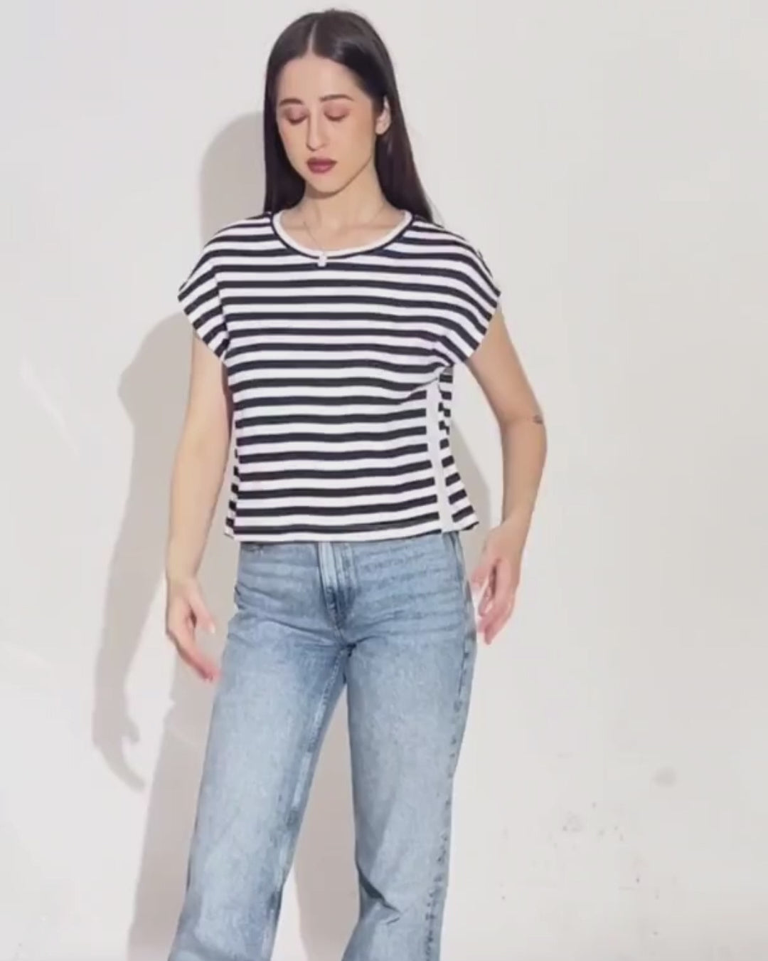 Model wearing striped T-shirt with relaxed fit and casual style