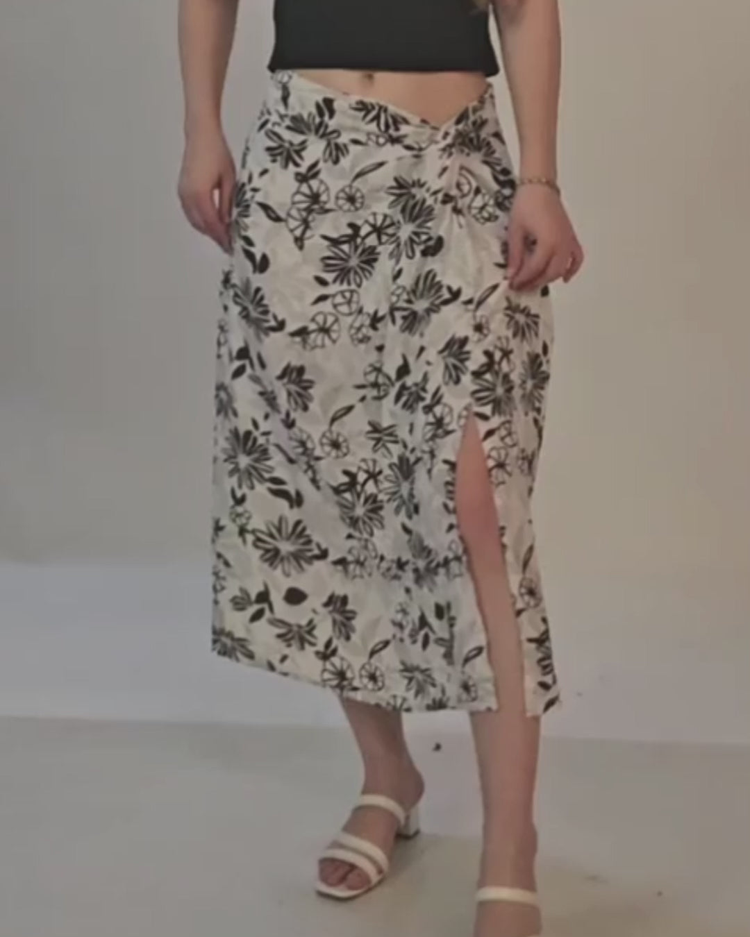 Photo of woman wearing floral wrap midi skirt with slit, styled with heels