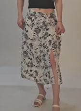 Photo of woman wearing floral wrap midi skirt with slit, styled with heels