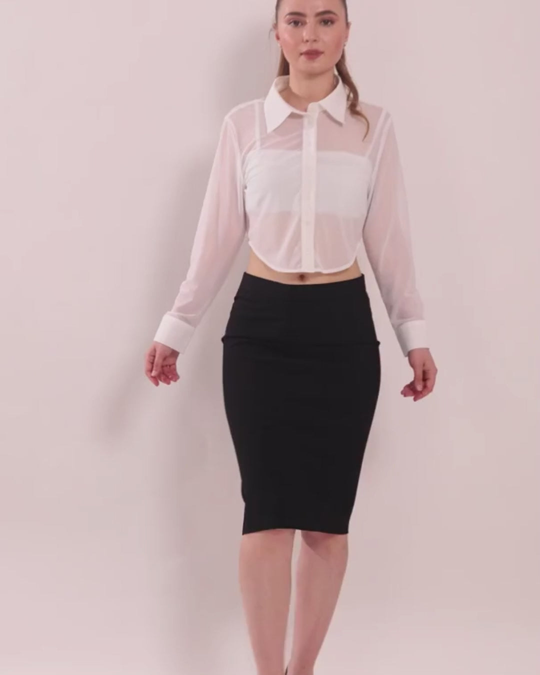 Model wearing white cropped shirt with long sleeves and button front
