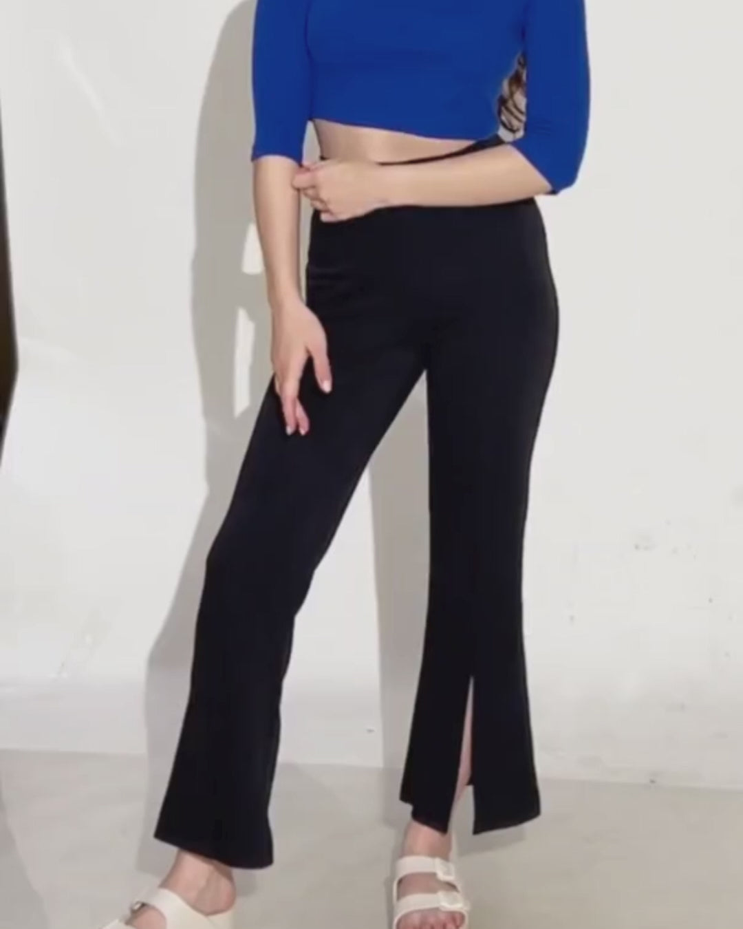 Model wearing black bell bottom pants with slit at hem, showcasing the sewing pattern