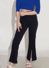 Model wearing black bell bottom pants with slit at hem, showcasing the sewing pattern