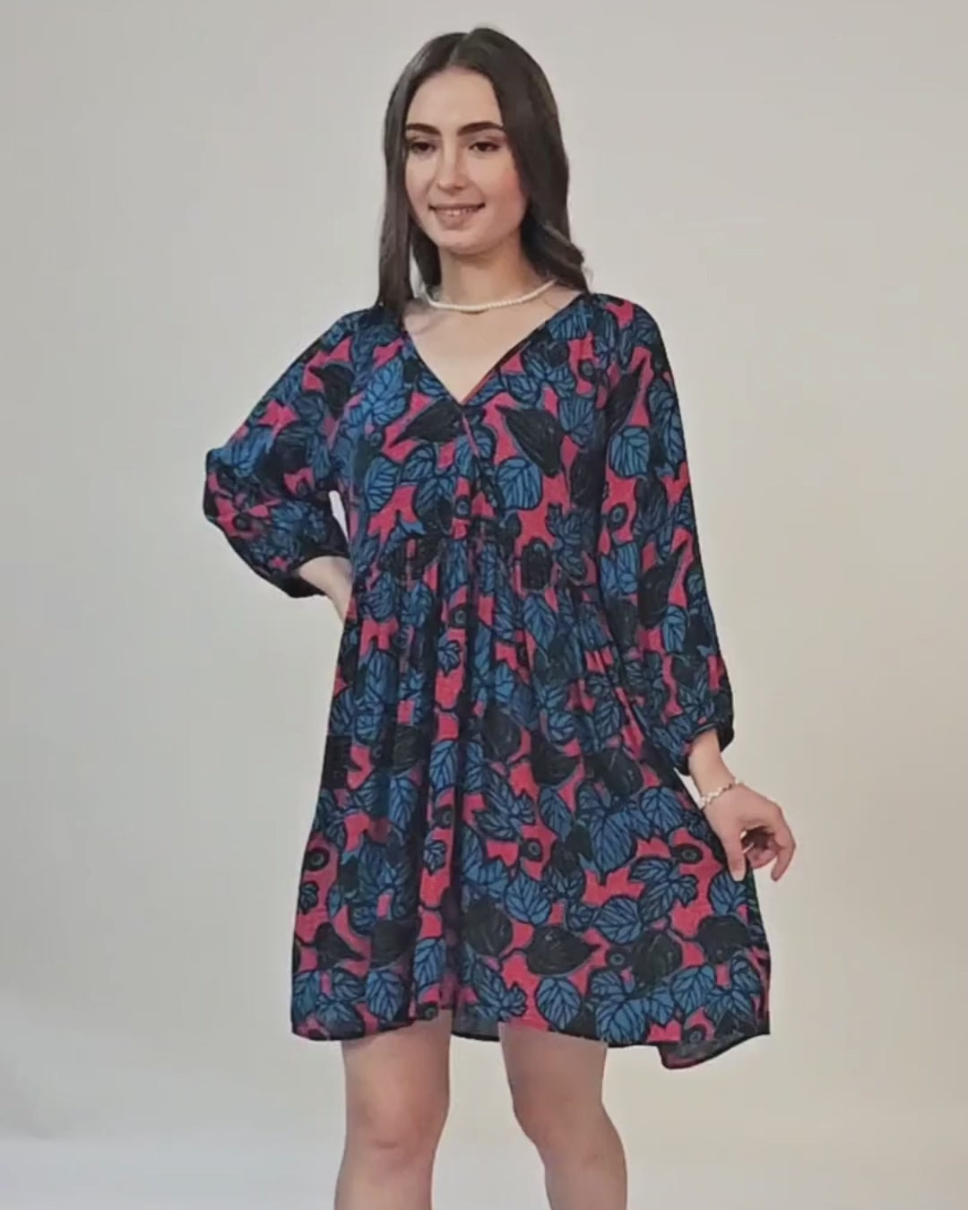 Woman modeling a boho dress with floral print, V-neck, long sleeves, and relaxed fit, showcasing the sewing pattern's style