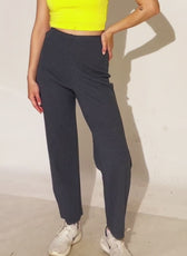 Model wearing dark gray pull-on pants in a casual setting. High-waisted design with a straight-leg fit for comfort and style.