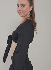 Side Pose Image of a model wearing a tie front crop top sewed with winslet's patterns paired with black midi skirt