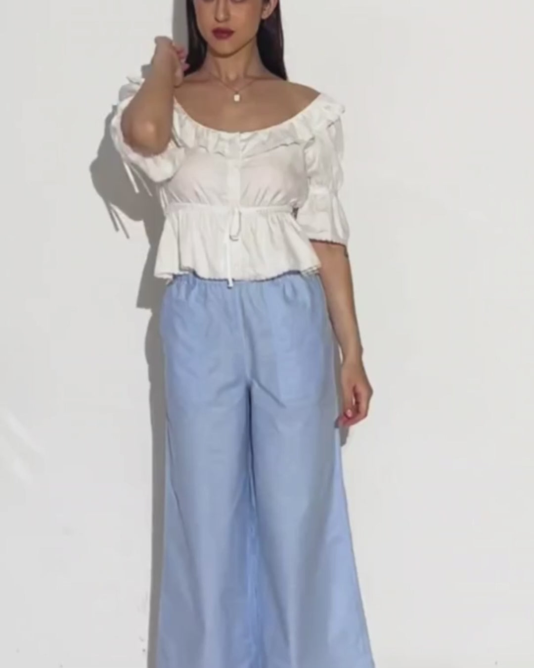 Model wearing wide leg trousers with a white top, demonstrating the style of the sewing pattern