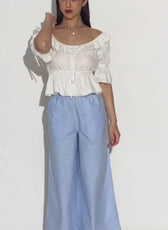 Model wearing wide leg trousers with a white top, demonstrating the style of the sewing pattern