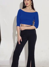 Model showcasing black flared pants with front slits in a stylish pose. Digital sewing pattern available for instant download with step-by-step instructions.